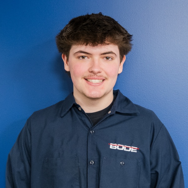 Headshot of Tim Yerian with blue background and bode jacket