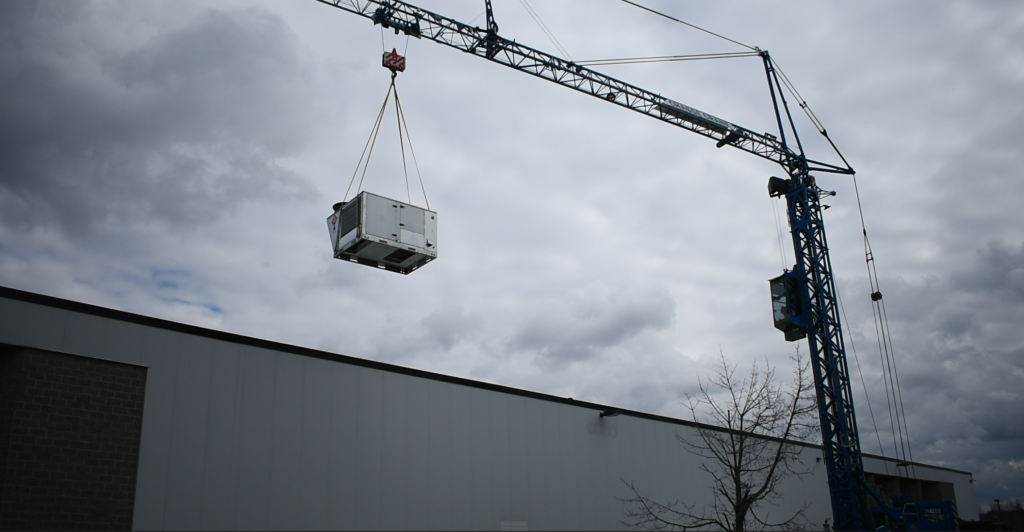 crane hoisting HVAC to roof