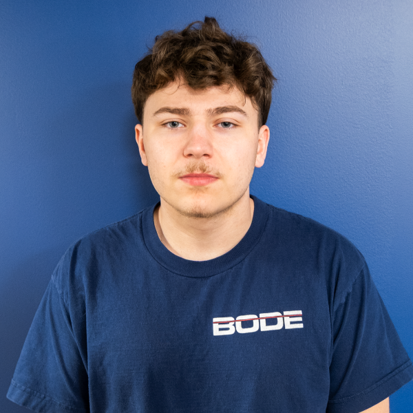 Headshot of Kayden Stubbert in front of blue wall with BODE wall