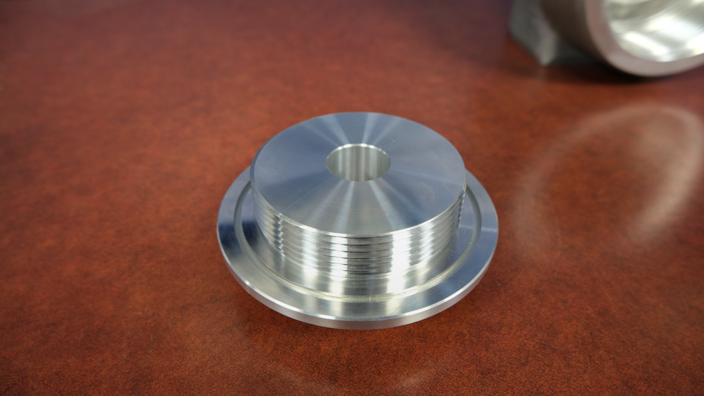 picture of an aluminum fitting cap on a wooden table